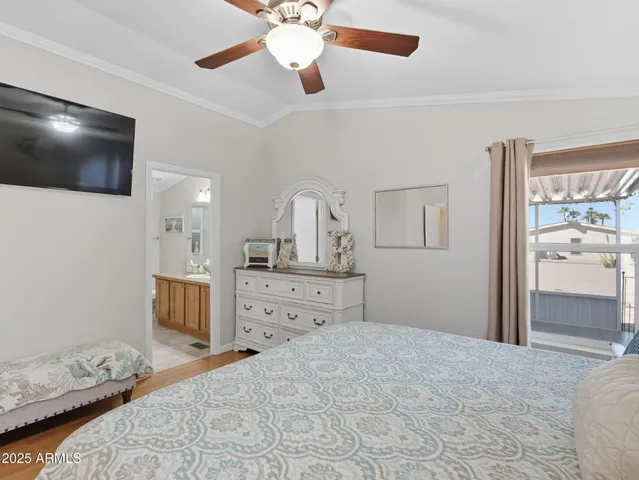 a bedroom with a large bed and a flat tv screen on dresser