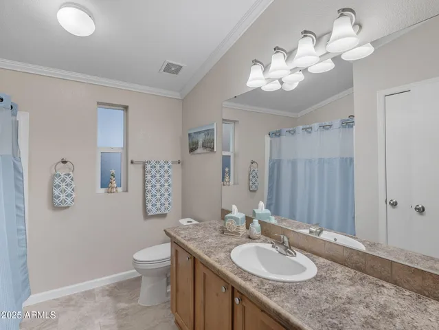a bathroom with a granite countertop sink a toilet and a mirror