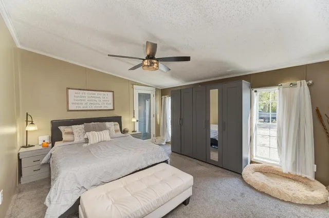 a bedroom with a bed and a large window