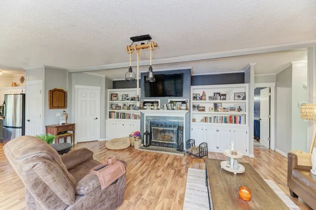 a living room with furniture a fireplace and a flat screen tv