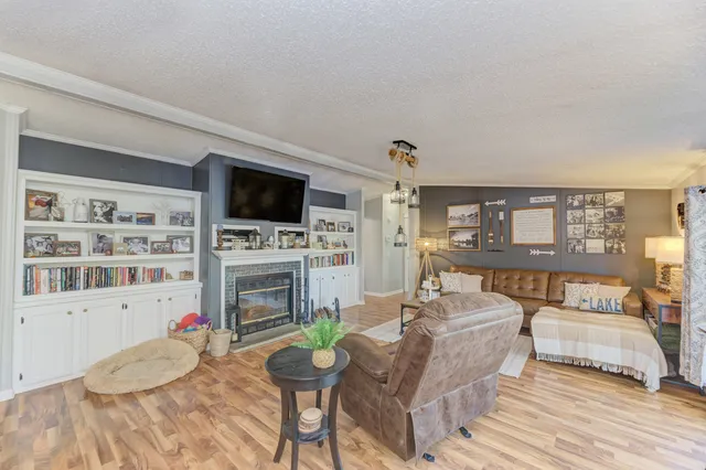 a living room with furniture a flat screen tv and a fireplace