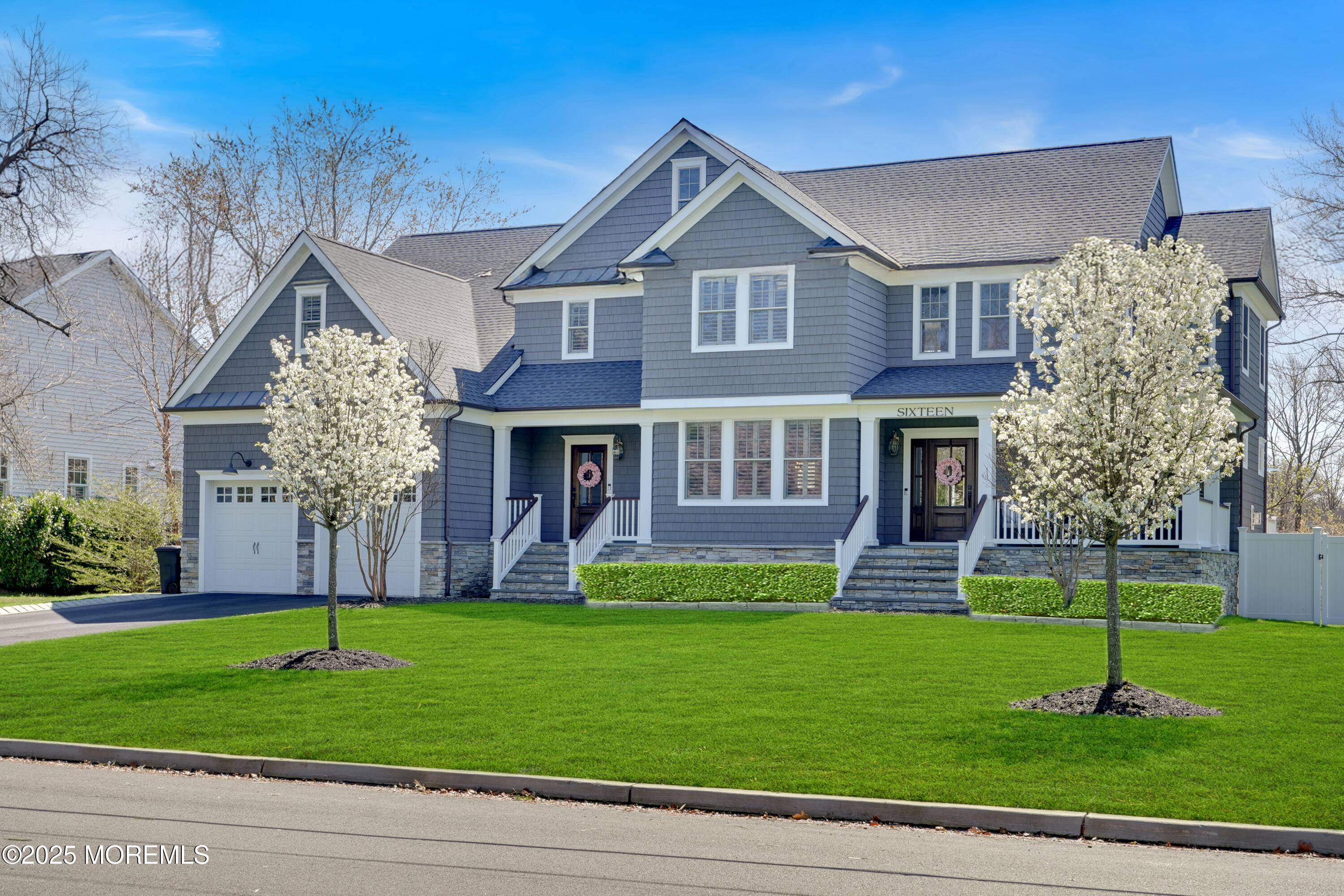 a front view of a house with a yard and trees