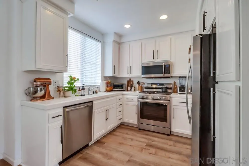 2221 Historic Decatur Road, Unit 61 San Diego, CA 92106 - Photo 14 of 29 a kitchen with stainless steel appliances granite countertop a stove a sink and a refrigerator