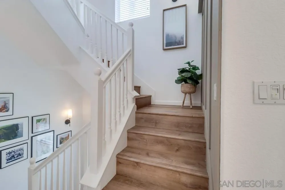2221 Historic Decatur Road, Unit 61 San Diego, CA 92106 - Photo 23 of 29 a view of staircase with lots of frames on wall and a potted plant
