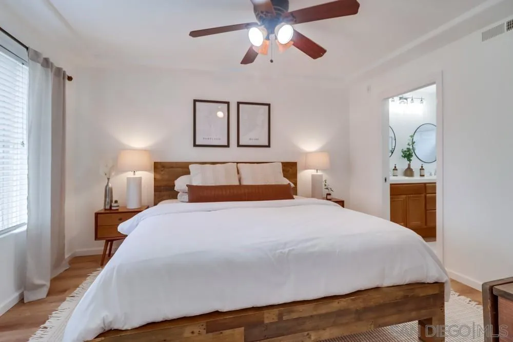 2221 Historic Decatur Road, Unit 61 San Diego, CA 92106 - Photo 27 of 29 a bedroom with a bed and a chandelier
