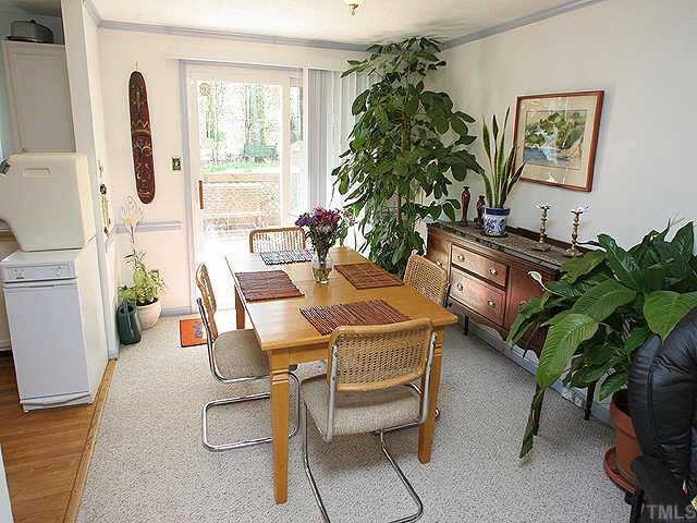 7301 Shellburne Drive Raleigh, NC 27612 - Photo 4 of 8 a living room with furniture a potted plant and a large window