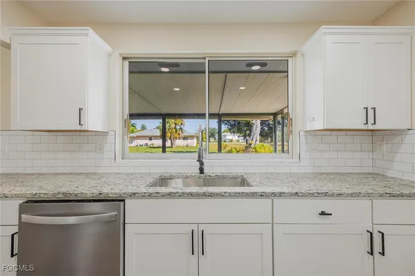 a kitchen with granite countertop a sink and cabinets