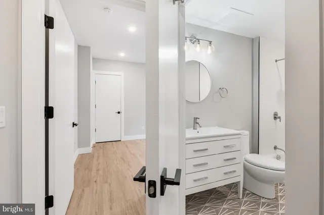 a bathroom with a sink a toilet and shower