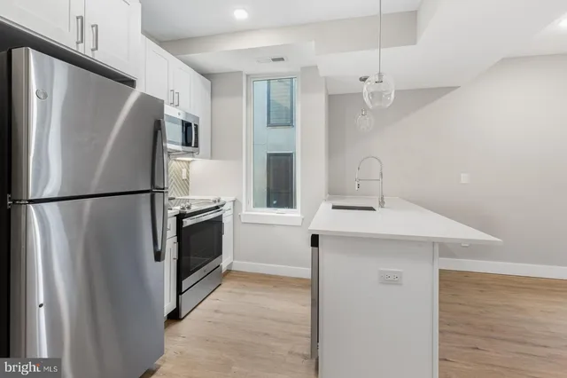 a kitchen with stainless steel appliances a refrigerator sink and microwave