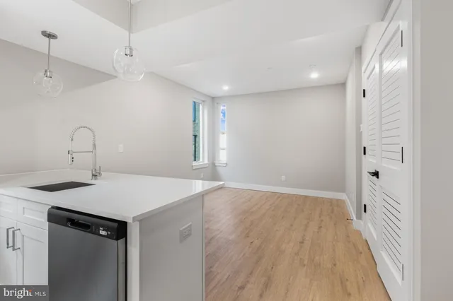 a kitchen with a sink a refrigerator and wooden floor