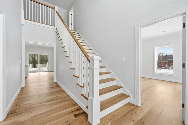 a view of a hallway with wooden floor and staircase