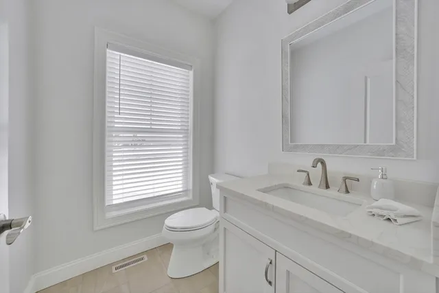 a bathroom with a sink a toilet and a window