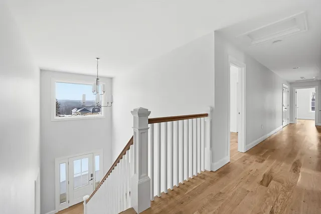 a view of a hallway with wooden floor and staircase