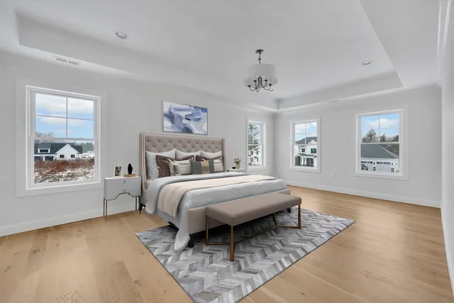 a spacious bedroom with a bed a window and dresser