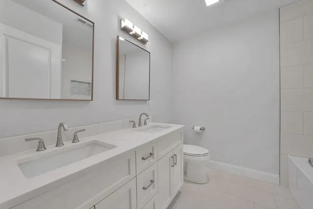 a bathroom with a toilet sink and mirror