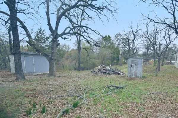 a view of a barn house in the middle of a forest