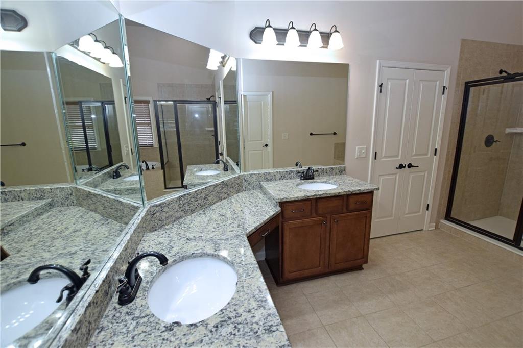 1630 Bramble Bush Way Suwanee, GA 30024 - Photo 13 of 31 a bathroom with a granite countertop sink and a mirror
