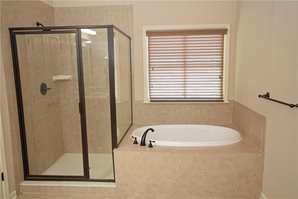 1630 Bramble Bush Way Suwanee, GA 30024 - Photo 14 of 31 a bathroom with a bathtub and a shower