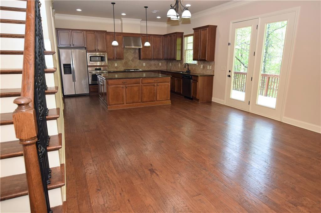 1630 Bramble Bush Way Suwanee, GA 30024 - Photo 2 of 31 a kitchen with stainless steel appliances granite countertop wooden floors and sink