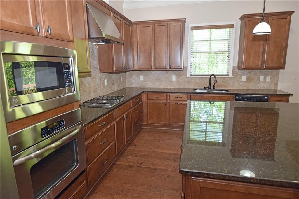 1630 Bramble Bush Way Suwanee, GA 30024 - Photo 5 of 31 a kitchen with stainless steel appliances granite countertop a stove a sink and a microwave
