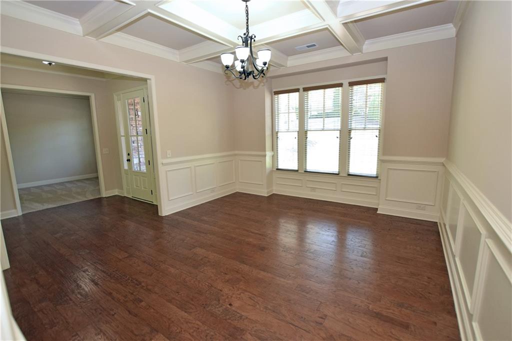 1630 Bramble Bush Way Suwanee, GA 30024 - Photo 7 of 31 an empty room with wooden floor chandelier and windows
