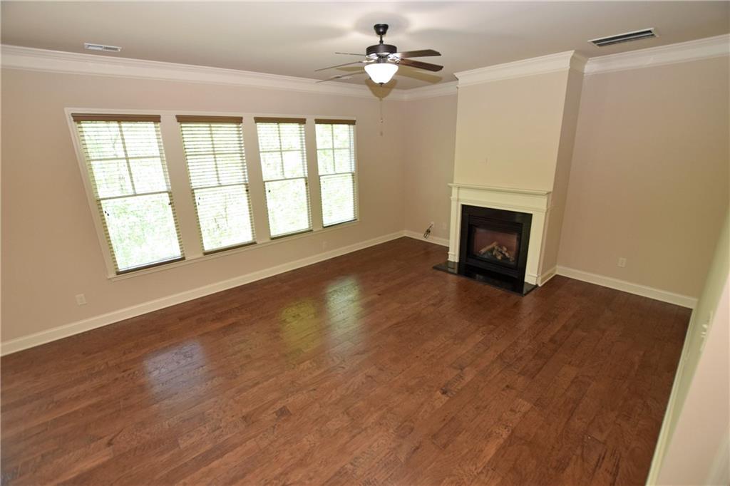 1630 Bramble Bush Way Suwanee, GA 30024 - Photo 10 of 31 wooden floor fireplace and windows in an empty room