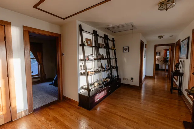 a view of an empty room with wooden floor and closet
