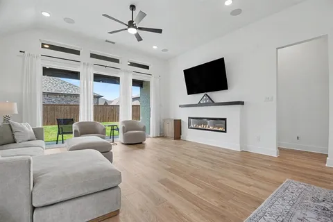 a living room with furniture a flat screen tv and a fireplace