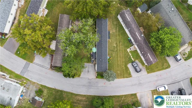 an aerial view of a residential houses with yard