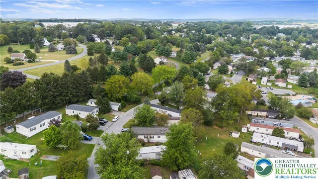 an aerial view of residential houses with outdoor space and trees