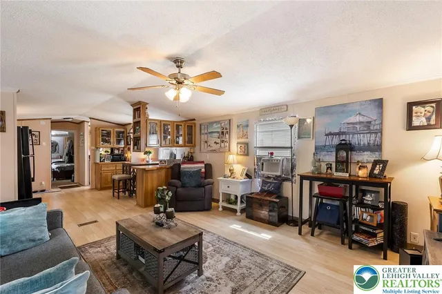a living room with furniture kitchen view and a large window