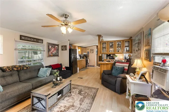 a living room with furniture ceiling fan and a window