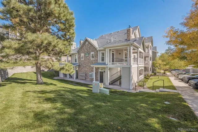 a view of a house with a big yard and large trees