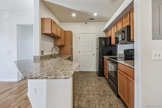 a kitchen with stainless steel appliances granite countertop a sink refrigerator and cabinets