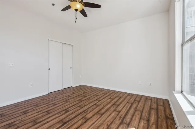a view of empty room with wooden floor