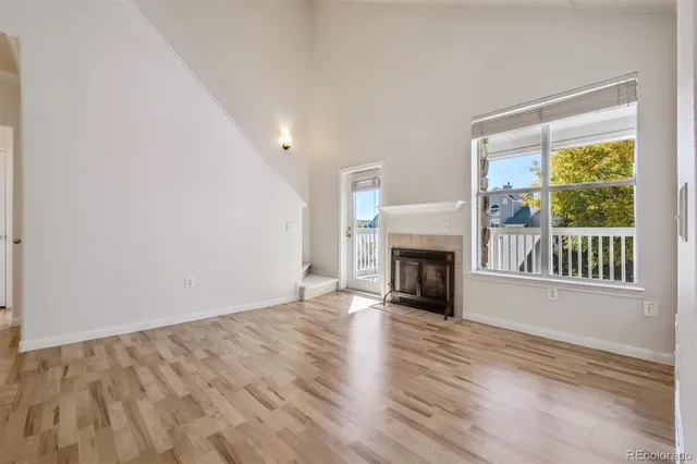 a view of empty room with wooden floor and fireplace