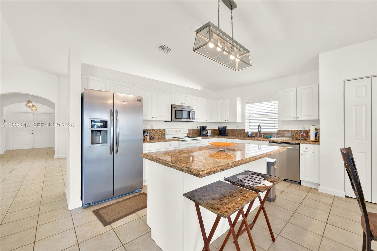 12046 Southwest 133rd Terrace Miami, FL 33186 - Photo 12 of 27 a kitchen with stainless steel appliances granite countertop a refrigerator and a stove top oven