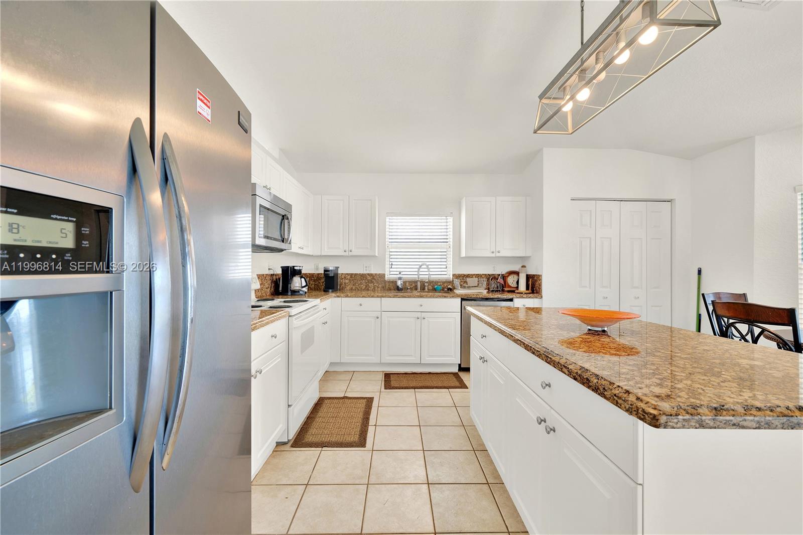 12046 Southwest 133rd Terrace Miami, FL 33186 - Photo 13 of 27 a kitchen with stainless steel appliances granite countertop a sink stove and refrigerator