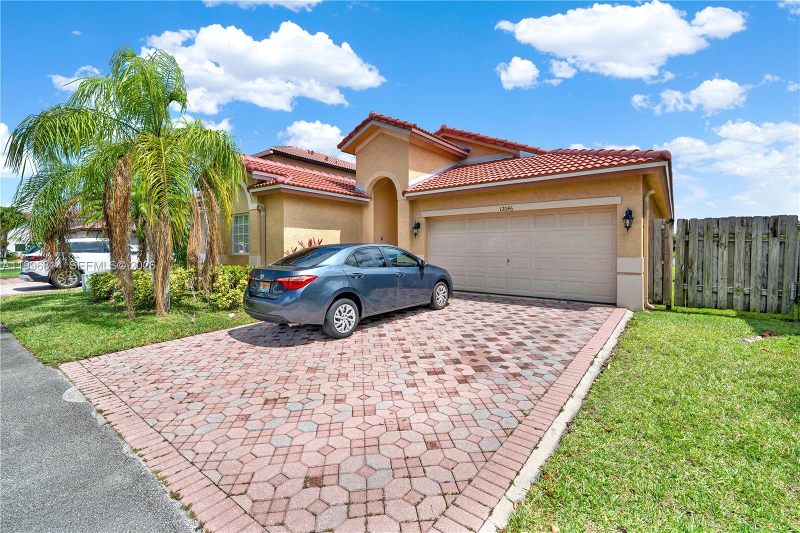 12046 Southwest 133rd Terrace Miami, FL 33186 - Photo 2 of 27 a front view of a house with a yard and garage