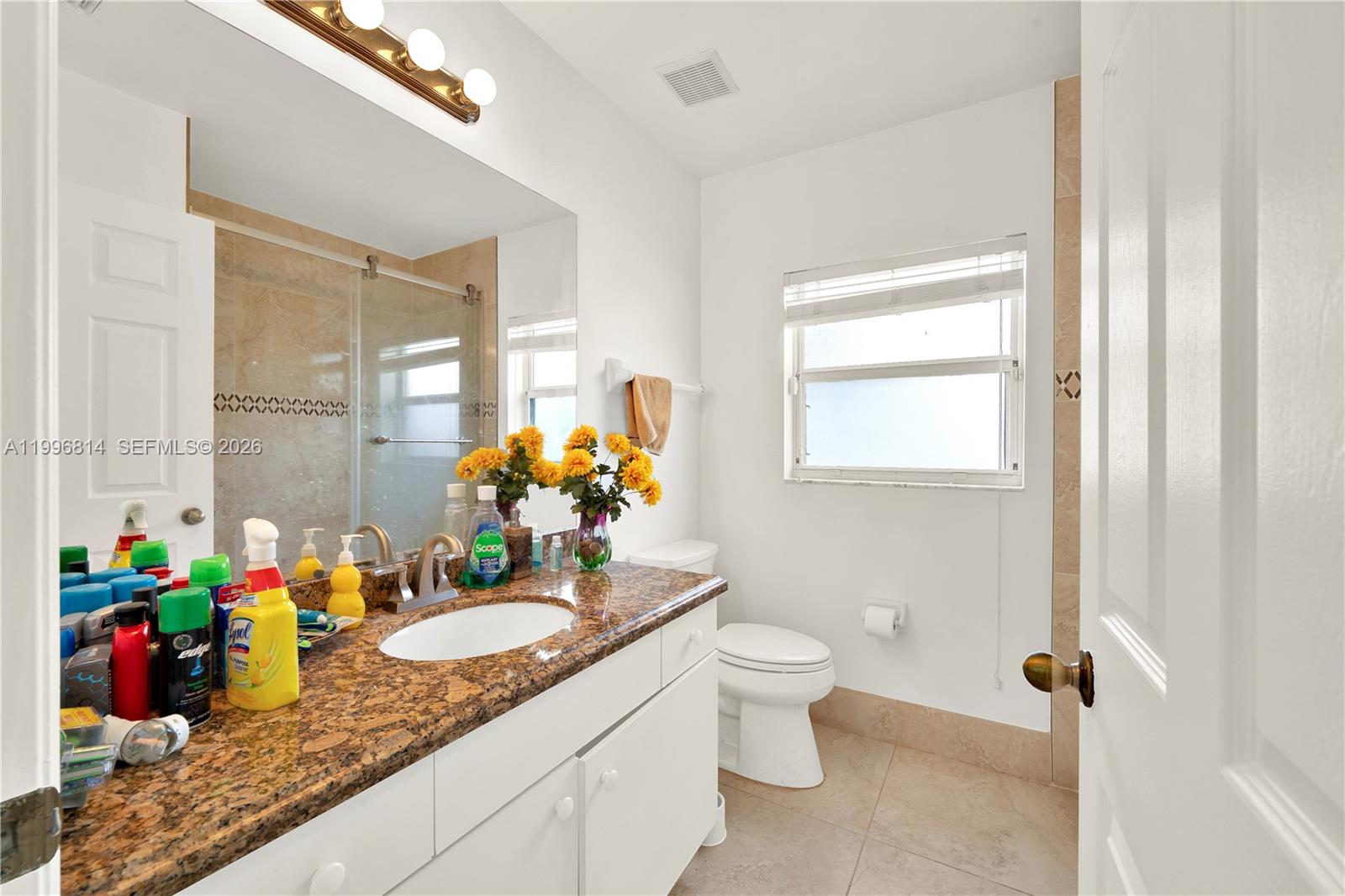 12046 Southwest 133rd Terrace Miami, FL 33186 - Photo 24 of 27 a bathroom with a granite countertop sink a toilet and a mirror