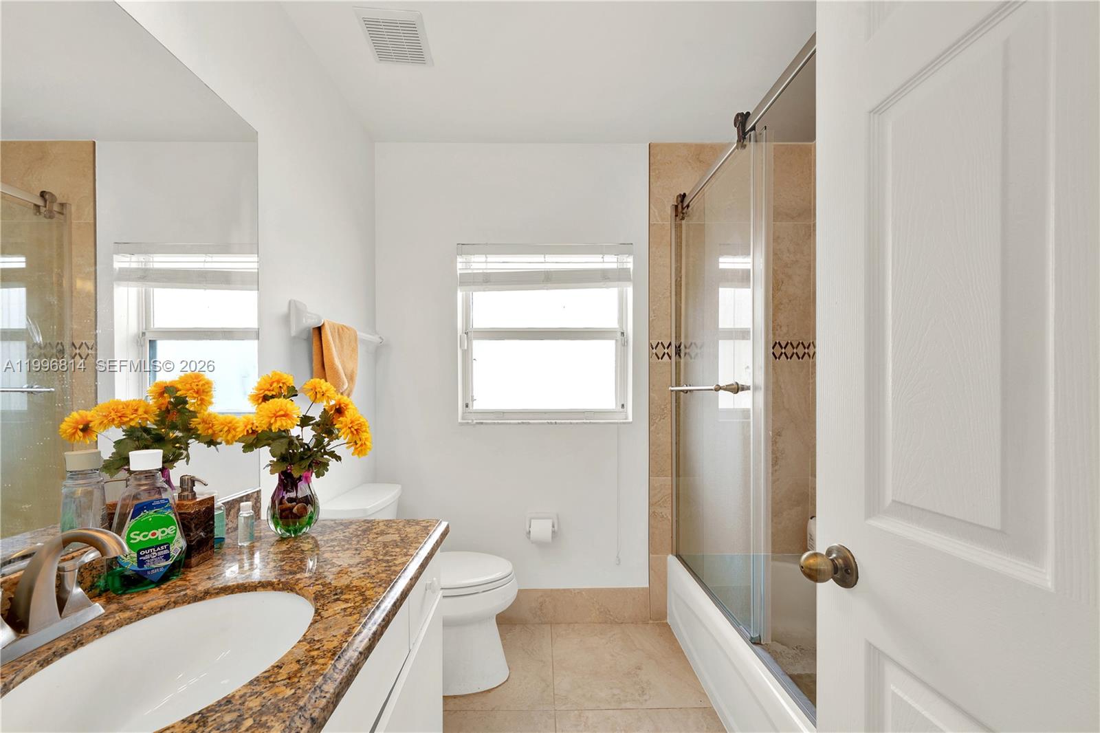 12046 Southwest 133rd Terrace Miami, FL 33186 - Photo 25 of 27 a bathroom with a granite countertop sink a mirror a bathtub and a shower
