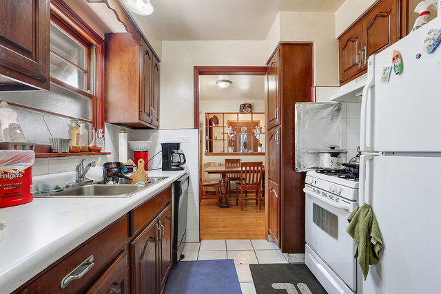 21W502 Army Trail Road Addison, IL 60101 - Photo 5 of 10 a kitchen with stainless steel appliances granite countertop a refrigerator a stove and a sink with wooden floor