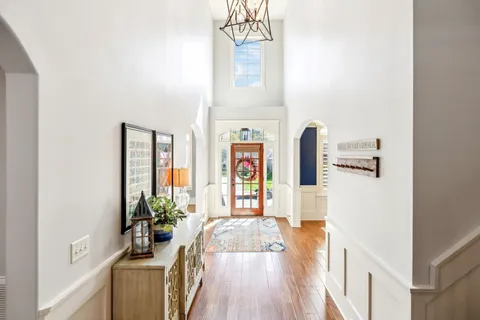 a living room with furniture kitchen view and a wooden floor