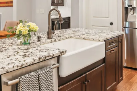 a bathroom with a granite countertop sink toilet and shower