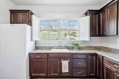 a view of a pathway both side of grassy field with shrub