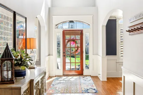 a view of a dining room with furniture a chandelier and wooden floor