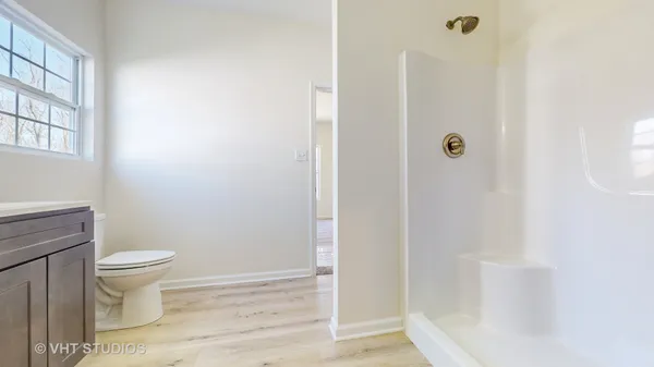 a bathroom with a toilet and a shower