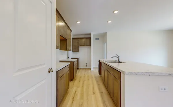 a kitchen with a sink and wooden floor