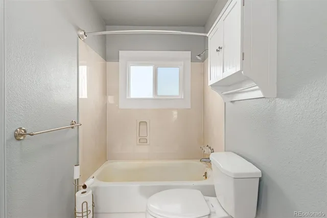a bathroom with a toilet and a bath tub