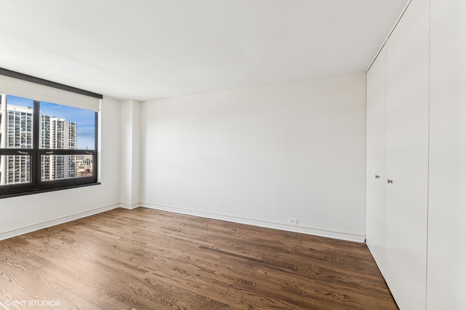 1410 North State Parkway, Unit 17B Chicago, IL 60610 - Photo 27 of 36 a view of an empty room with wooden floor and a window